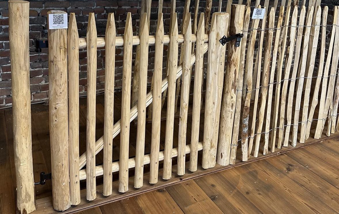 Kastanjehouten tuinpoortje met zwart beslag, gemonteerd als onderdeel van een compleet kastanje hekwerk