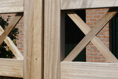 Detail van de Brussels-poort in Iroko hardhout, tonend de solide pen-en-gatverbinding en de strakke afwerking van de gekruiste latten.