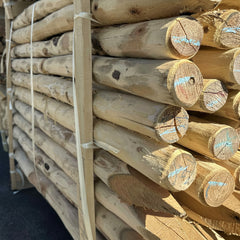 Stapel duurzame Robinia ronde palen diameter 8-10 cm ontschorst en gepunt - Prindal Hout